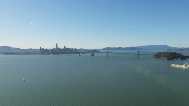 在奥克兰海湾大桥附近的海洋集装箱船的空中阳光视图旧金山城市摩天大楼宝藏岛加利福尼亚美国 — 图库视频影像