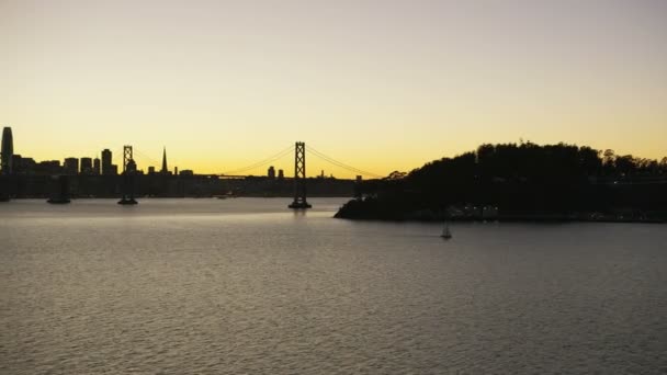 空中夕暮れライトアップされたオークランド湾道路橋梁私たち 高速道路 サンフランシスコ市高層ビル明らかに宝の島カリフォルニア アメリカの眺めを明らかにします — ストック動画