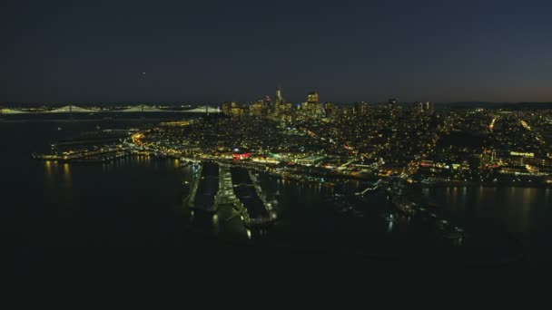 空中照射フィッシャーマンズ ワーフ は北ビーチ サンフランシスコ湾オークランズ湾橋カリフォルニア アメリカの都市の景観夜景 — ストック動画