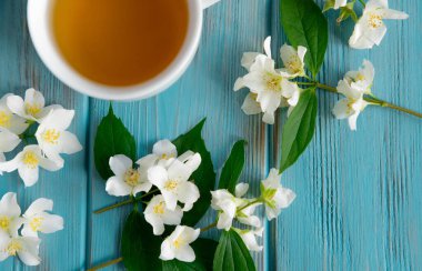 Mavi ahşap arka planda Yasemin çayı. Rahatlatıcı yasemin çayı. Rahatlama ve sağlık için aromatik çaylar