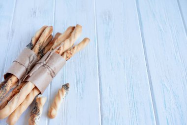 Bir fırının arka planı, fırın ürünlerinin satışı için bir bölüm. Gri ahşap zemin üzerinde ekmek ve ekmek çubuklarının fotoğrafı. Ev yapımı ekmek.