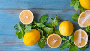 Mavi ahşap kaplamalı ve fotokopi alanı için yeri olan dilimlenmiş taze limonlar. Turunçgil meyveli arka plan. C vitamini taze limon arkaplanı. Düz yatış, üst görünüm.