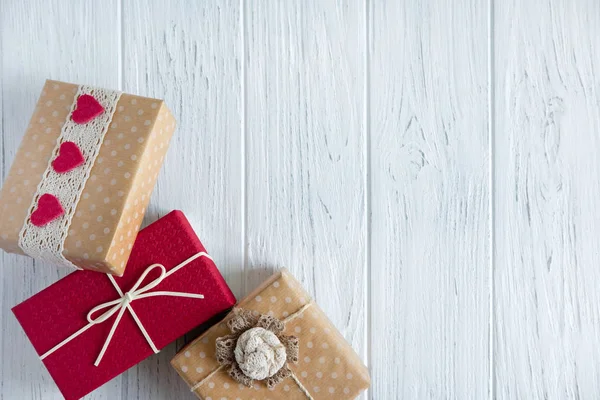 Tres regalos se cierran sobre un fondo de madera clara con un lugar para el espacio de copia. Marco para texto con cajas de regalos. Fondo para la venta banner, descuento, descuentos . — Foto de Stock