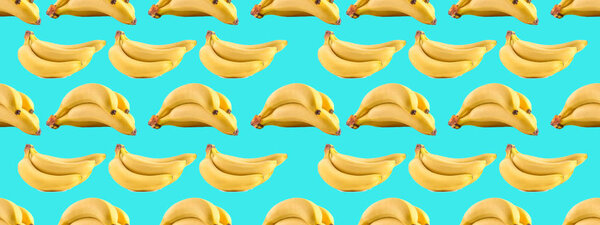 Seamless photo pattern with bananas on a blue background. Creative background for banner, website, advertisements, business cards and special offers with fruits. Background with vitamins