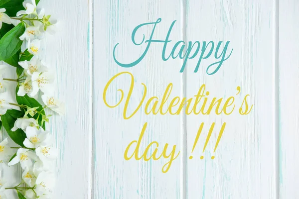 Happy Valentine's day. Greeting card with the inscription and jasmine flowers on a light wooden background. Postcard template for email newsletter. — Stock Photo, Image