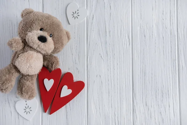 Fondo para una tarjeta de felicitación con un oso de juguete y corazones. Antecedentes para el Día de San Valentín, felicitaciones a mamá, niña, hija. Piso tendido, vista superior . — Foto de Stock