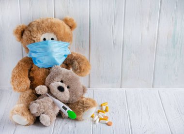 Çocuklardaki viral hastalıkların kavramsal geçmişi. Sıcaklık, burun akışı, grip, koronovirüs. Virüslerin tedavisi için çocuk kliniği. Virüs maskeli oyuncak ayı. Pediyatri Kliniği