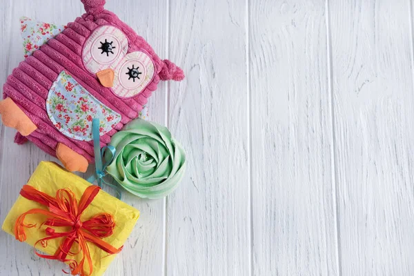 Antecedentes de felicitación sobre el nacimiento de una niña con un búho de juguete rosa, un regalo y dulces en un palo. Esta es una chica. Tarjeta de felicitación para un cumpleaños y para una promoción en una tienda infantil . — Foto de Stock