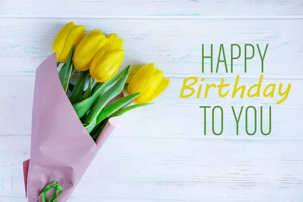 Birthday greeting card with yellow tulips and the inscription on a light wooden background. Greeting card for posting, blog posting for a birthday. View from above — Stock Fotó