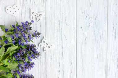 Kır çiçeklerinin arka planı. Doğal renklere sahip bir afiş için arka plan. Copyspeis Çiçekli Afiş. Çiçek arka plan. Beyaz ahşap arka plan üzerine çiçekler