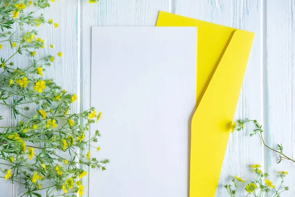 Mock up template with yellow wildflowers on a wooden background. Frame for an inscription, text with flowers. Flat lay, top view. — Stock Fotó