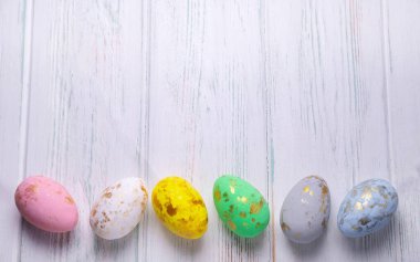 Tebrik kartı, stok ve afiş için paskalya arkaplanı. Hafif ahşap arka planda Paskalya yumurtaları. Yukarıdan görüntüle.