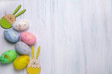 Tebrik kartı, stok ve afiş için paskalya arkaplanı. Hafif ahşap arka planda Paskalya yumurtaları. Yukarıdan bak. Kopya alanı olan Paskalya yumurtaları