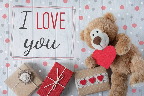 I love you. Greeting card Valentine. Declaration of love. Teddy bear with a heart and boxes with gifts.