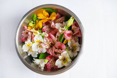 Çok renkli alstroemeria çiçeklerini yuvarlak, kalın bir tabakta, yazıtlar için bir yeri olan yakın plan. Arka planda parlak alstromerya çiçekleri.