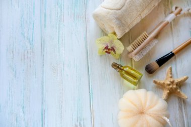 Deniz yıldızı, bez ve vücut fırçasıyla kaplıca bileşimi. Aromaterapi teması üzerine kompozisyon. Hafif ahşap arka planda yazılar var. Yukarıdan görüntüle