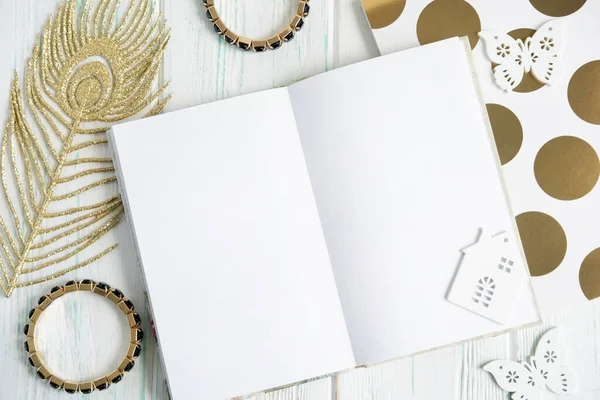 Bir defter ayarlayın. Bilezikli güzellik çerçevesi, açık ahşap arka planda altın renkli tüy..
