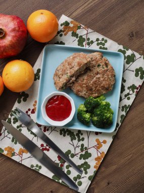 Hamburger biftek, brokoli, ketçap ve meyve