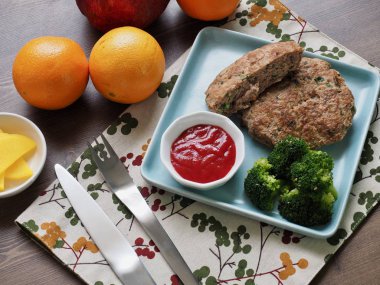 Hamburger biftek, brokoli, ketçap ve meyve