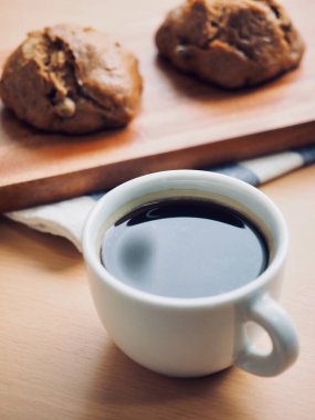 Tahta arka planda kahve ve ekmek var.