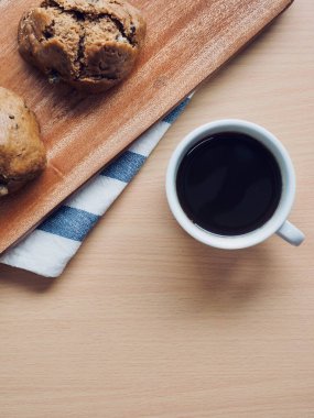 Tahta arka planda kahve ve ekmek var.