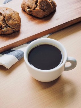 Tahta arka planda kahve ve ekmek var.