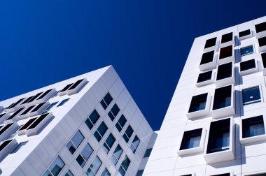 Mavi gökyüzüne karşı modern beyaz gökdelenler