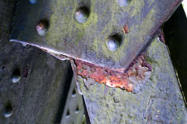 Eski perçinlenmiş ve yıpranmış çelik plakalar.