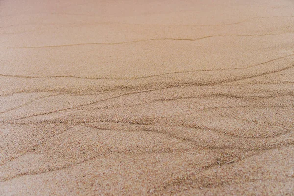 Hnědý písek textura pozadí z jemného písku s přírodní linií vlny. — Stock fotografie