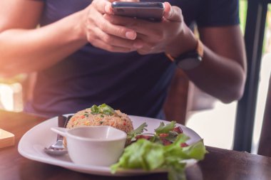 Lokantada cep telefonuyla fotoğraf çeken adam sosyal ağlarda güzel iletişim kuruyor..