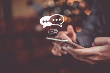 Kadınlar akıllı cep telefonu yazma, sohbet kutusu ikonlarında sohbet etme kullanırlar. Sosyal medya teknolojisi kavramı. Klasik yumuşak renk tonu arkaplanı.