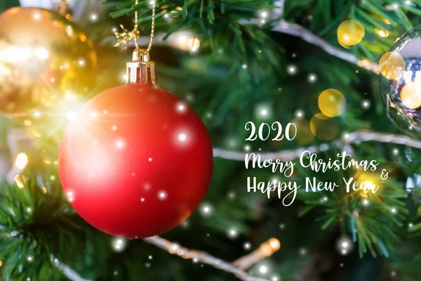 Decorado cerrado árbol de Navidad en borrosa, brillante nevada y fondo abstracto de hadas de luces de vacaciones bokeh con Feliz Navidad y Feliz Año Nuevo 2020 texto . — Foto de Stock