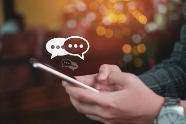 Kadınlar akıllı cep telefonu yazma, sohbet kutusu ikonlarında sohbet etme kullanırlar. Sosyal medya teknolojisi kavramı. Klasik yumuşak renk tonu arkaplanı.