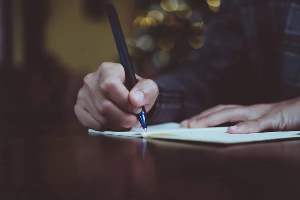 Femme écriture à la main dans un petit carnet de notes blanc pour prendre une note à ne pas oublier ou à faire un plan de liste . — Photo