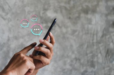Kadınlar akıllı telefon daktiloyla yazı yazıp sohbet ediyorlar. Sohbet kutusu simgeleri ortaya çıkıyor. Sosyal medya teknolojisi kavramı.
