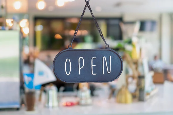 En företagsskylt där det står Öppet på café eller restaurang hänger på dörren vid entrén. Vintage färg ton stil. — Stockfoto