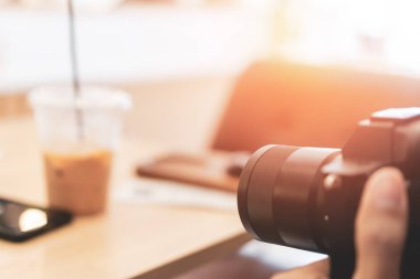 Selective focus of DSLR camera shooting object in cafe.