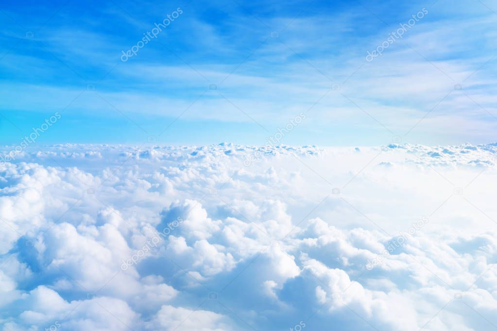 Airplane window view above beautiful white cloud summer blue sky and sun light abstract nature.