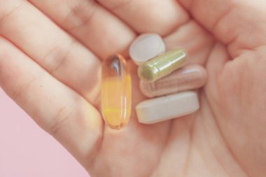 Alternatif organik tıp veya bitkisel viatmin ilave kapsül tabletinin kadın eli üzerinde telif alanı arka planına sahip üst görünümü.