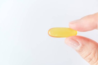 Top view of alternative organic medicine or herbal viatmin supplement capsule tablet on woman hand with copyspace background. Concept of healthy eating.