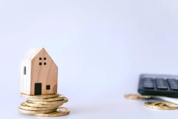 Mini modèle de maison sur pièce d'or avec fond blanc imitation propre. Entreprises investir l'épargne immobilière . — Photo