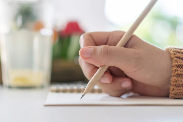 Femme écriture à la main dans un carnet de notes blanc pour prendre une note à ne pas oublier, faire la liste ou planifier pour le travail à l'avenir sur la table de travail . — Photo