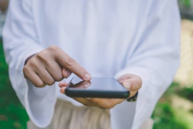 Kadın iş yapmak için akıllı telefonu kullanıyor, sosyal ağ, kamusal alanda iletişim..