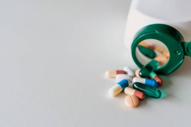 İlaç tabletlerinin üst görüntüsü mermer desenli beyaz arka plan haplarından akıyor. Sağlık hizmetleri tıbbi yaşam tarzı eğilimi kavramı.