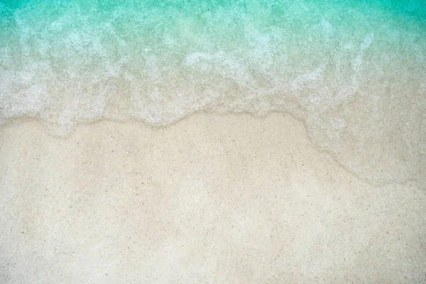 Top view of sand and water clean beach and white sand in summer with sun light blue sky and bokeh abstract  background.