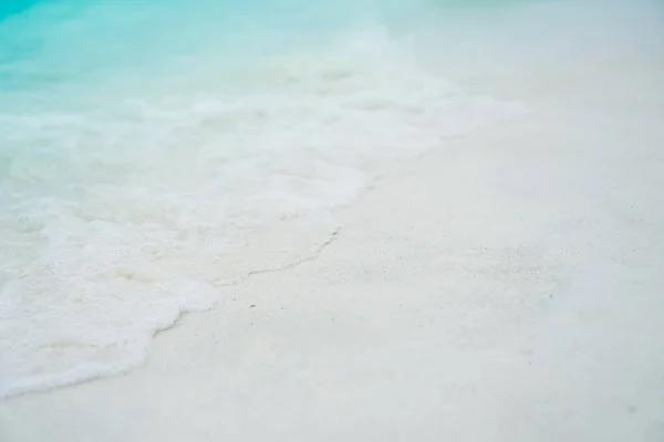 Top view of sand and water clean beach and white sand in summer with sun light blue sky and bokeh abstract  background.
