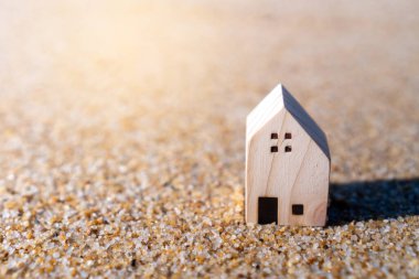 Doğanın plaj geçmişine sahip kumlu küçük bir evin modeli. Rüya hayat konsepti.