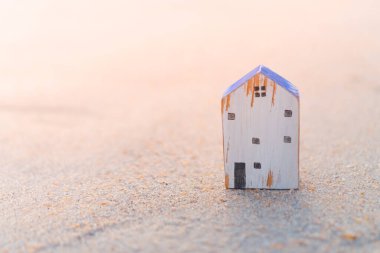 Doğanın plaj geçmişine sahip kumlu küçük bir evin modeli. Rüya hayat konsepti.