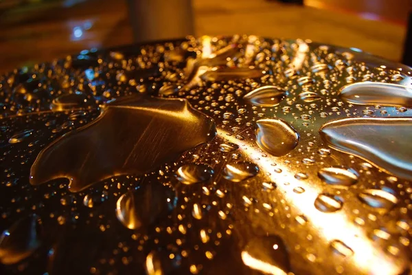Waterdruppels verlichte op metalen pijler Stockfoto