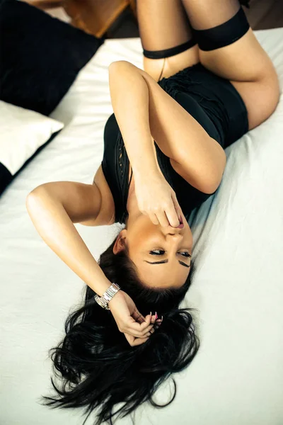 Acostado en la cama del hotel con ropa sexy — Foto de Stock